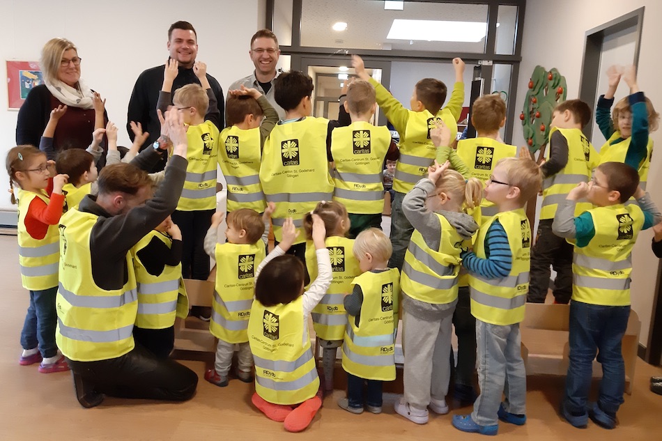 Bärbel Wille (l.) freut sich mit den Kindern über die Warnwesten. Foto: Caritas