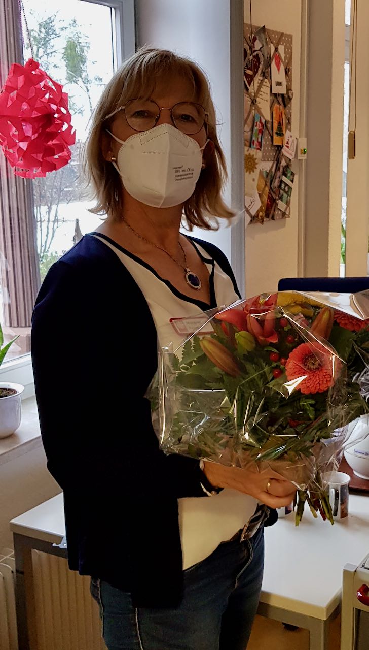Margret Papen erhält einen Blumenstrauß zum 10-jährigen Dienstjubiläum als Mitarbeiterin der Caritas Tagespflege Duderstadt. | Foto: Caritas Südniedersachsen