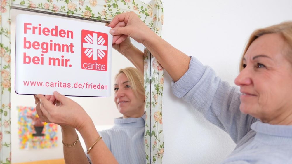 Christine Emmel klebt das Kampagnen-Motto auf den Spiegel im Mädchencafé im Hammeln. | Foto: Chris Gossmann