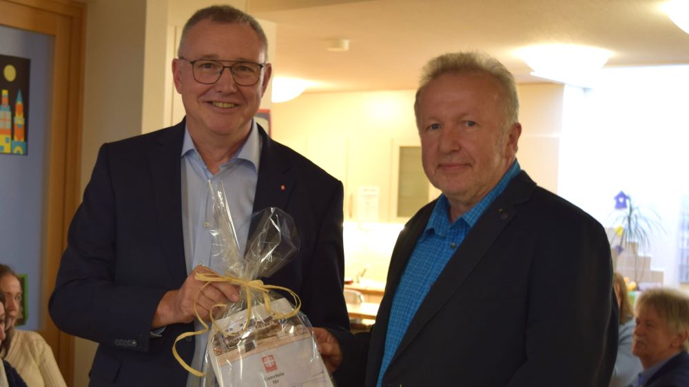 Caritas-Vorstandssprecher Ralf Regenhardt (l.) überreicht Gerd Hegerkamp zum Abschied einen Gutschein für einen Aufenthalt auf Wangerooge. | Foto: Johannes Broermann / cps