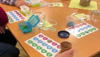 Herz-Würfelbingo fördert die Konzentration und die Motorik der Teilnehmenden in Carena-Gruppen. | Foto: Caritas