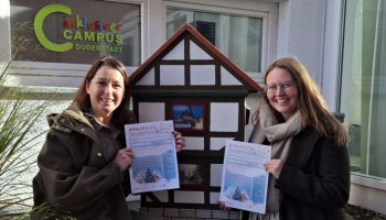 Janine Möller (links) und Emma Fuckner zeigen den Wunschzettel 2025 vor dem Fachwerkhäuschen-Briefkasten am Inklusiven Campus Duderstadt. | Foto: Caritas