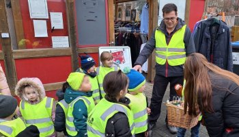 Das Foto zeigt eine Gruppe Kinder mit ihrem Betreuer vor dem Caritex-Laden Northeim.