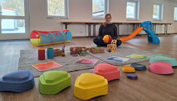Inmitten von Kleinkinderspielzeug sitzt Janina Wilharm.