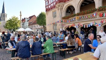 Menschen sitzen beim Picknick vor dem Historischen Rathaus Duderstadt