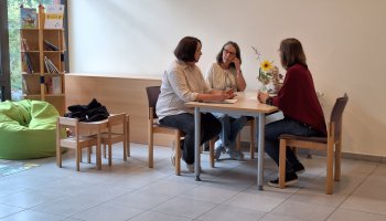 Drei Personen sitzen an einem Tisch
