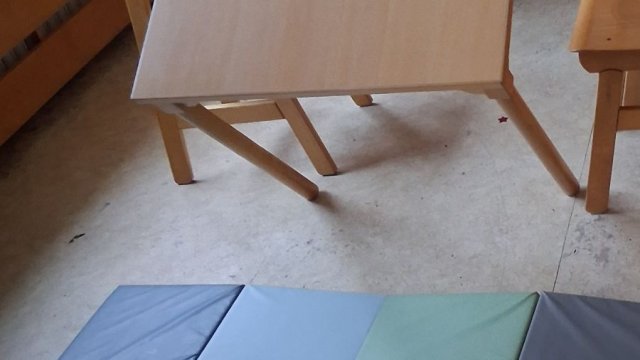 Das Foto zeigt einen schrägen Tisch und davor eine weiche Matte.