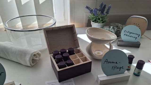 Bei einer Sterbebegleitung bieten sich Hilfsmittel an, etwas eine Aromapflege. | Foto: Caritas Das Foto zeigt einige Hilfsmittel bei der Sterbebegleitung, beispielsweise Fläschchen mit Aromatropfen, eine Glasschüssel und ein Handtuch.