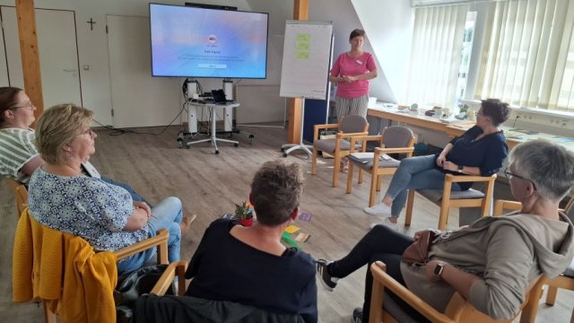 Leandra Conradi  vermittelte Grundlagen der Sterbebegleitung. | Foto: Caritas Das Foto zeigt einen Stuhlkreis mit Teilnehmenden und die Kursleiterin Leandra Conradi stehend.