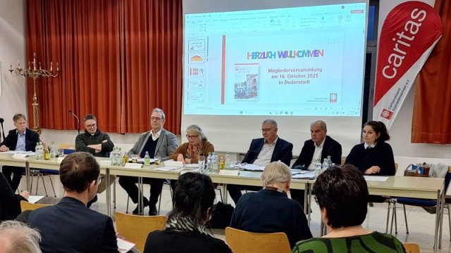 Annelore von Hof leitet durch die Versammlung. | Foto: Johannes Broermann Das Bild zeigt Mitglieder des Caritasrats und des Vorstandsteams, wie sie gemeinsam der Mitgliederversammlung vorsitzen.