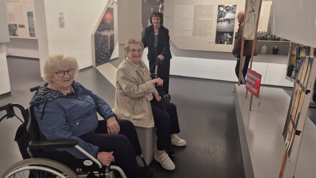 Menschen betrachten die Ausstellung zum Mauerfall. 