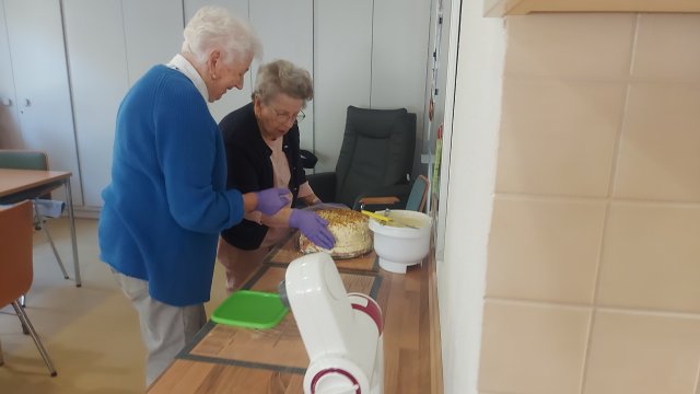 Zwei Frauen dekorieren einen Kuchen
