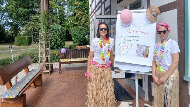 Zwei Frauen stehen neben einem Plakat