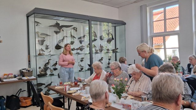 Menschen stehen oder sitzen. 