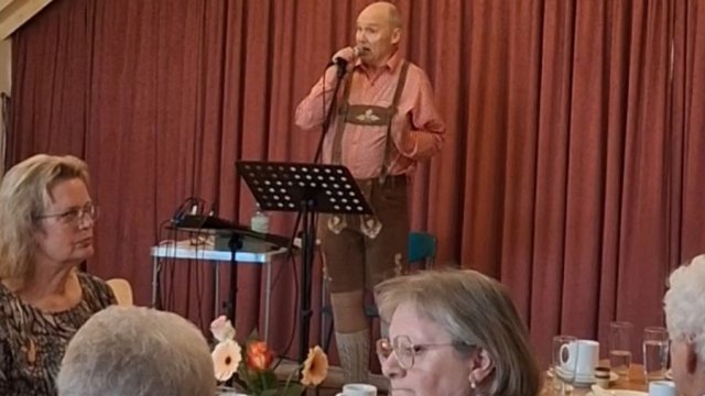 Das Foto zeigt einen Musiker in Lederhose und kariertem Hemd.