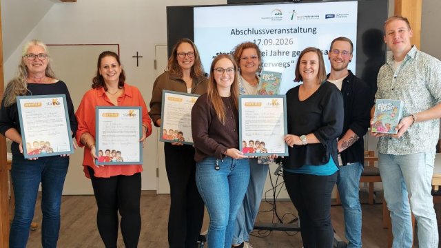 Eine Gruppe Menschen zeigt ihre Zertifikate.
