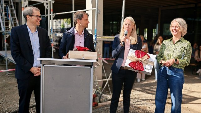 Vier Personen stehen hinter einem Rednerpult