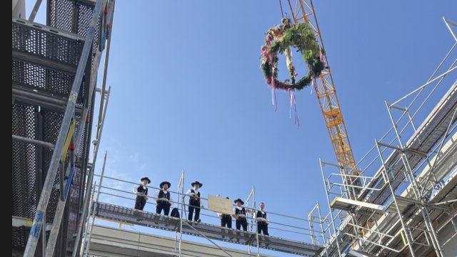 Handwerker stehen oben auf dem Rohbau.