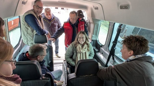 Das Foto zeigt, wie eine Person im Rollstuhl in einem Kleinbus transportiert werden kann.