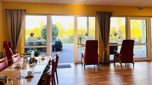 Das Foto zeigt Tische und Stühle sowie einen Blick nach draußen auf die Terrasse.