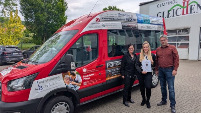 Das Foto zeigt drei Personen vor einem roten Minibus mit vielen Werbeplätzen.
