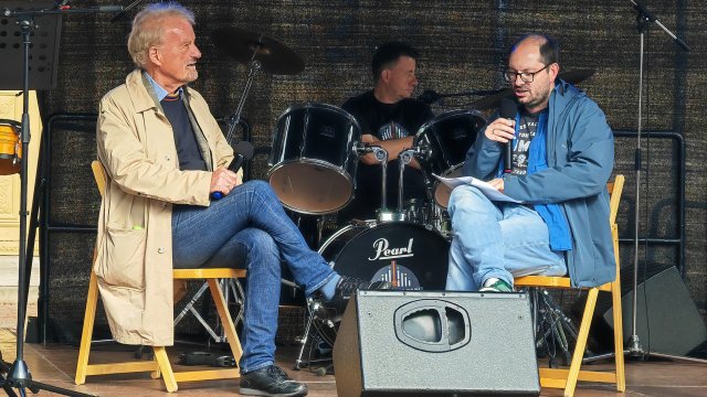Auf einer Bühne sitzen zwei Personen und unterhalten sich.