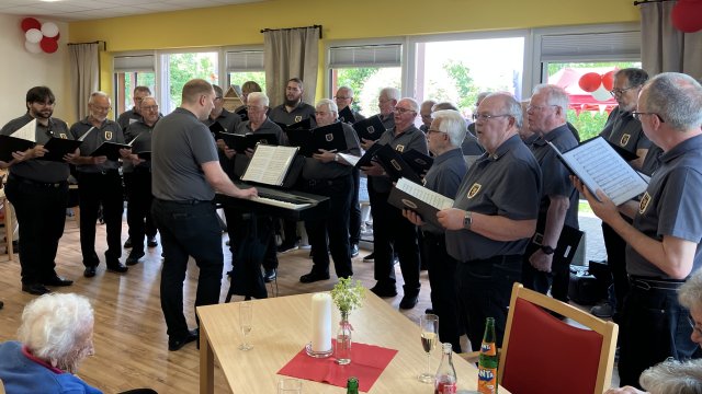 Das Foto zeigt einen Männerchor, alle sind schwarz gekleidet.