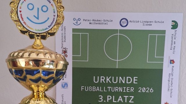 Es ist ein Pokal und eine Urkunde zu sehen 